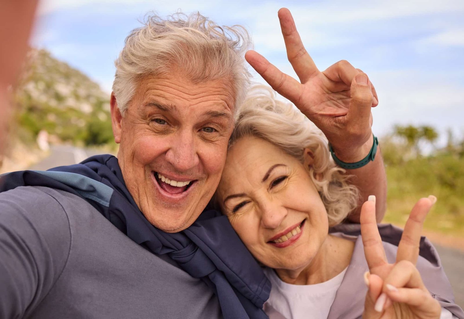 senior couple fitness selfie with peace sign smile outdoor nature portrait together elderly man woman hand emoji health love profile picture training workout