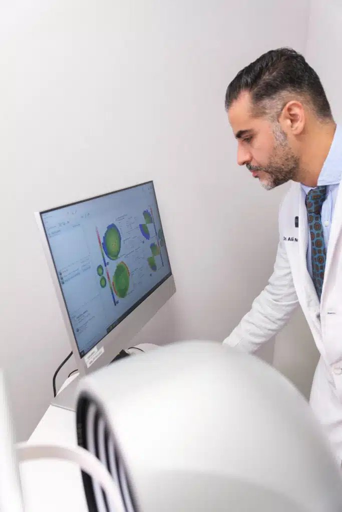 El Dr. Nowrouzi revisa en la pantalla los mapas de la córnea de un paciente