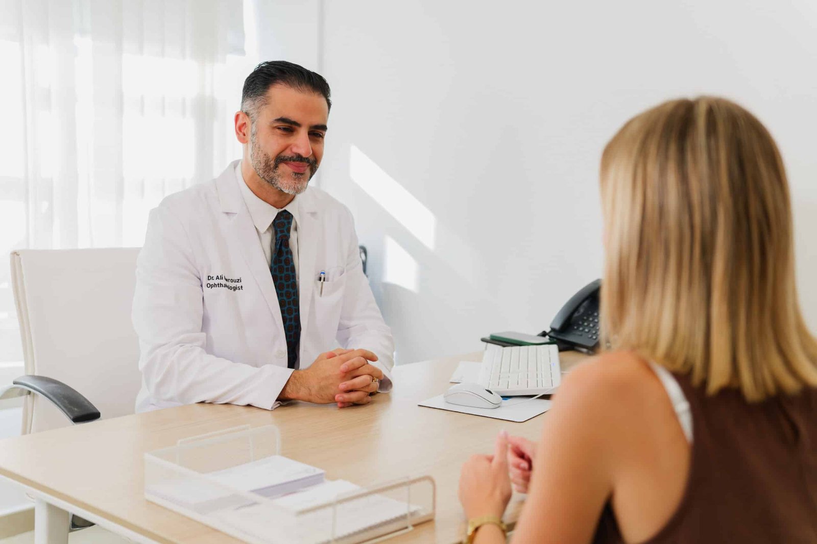 Médico en consulta con paciente en un entorno profesional, discutiendo opciones de tratamiento.